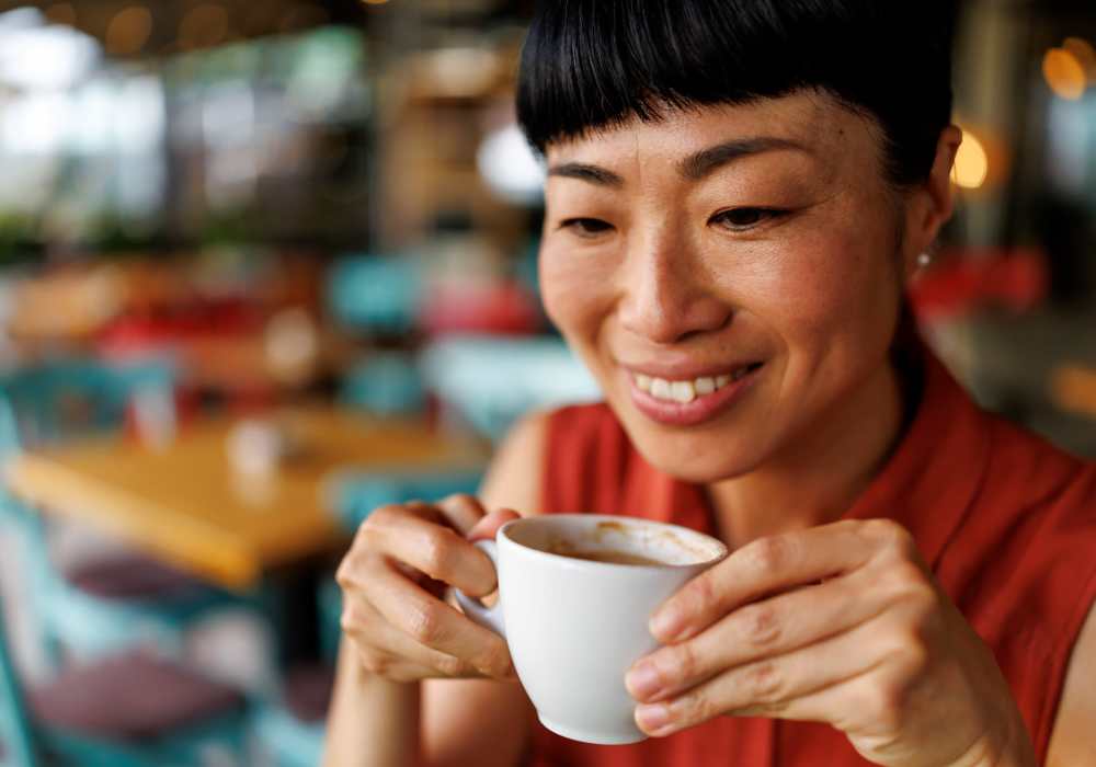 Woman enjoying coffee at café near Redwood in San Marcos, Texas