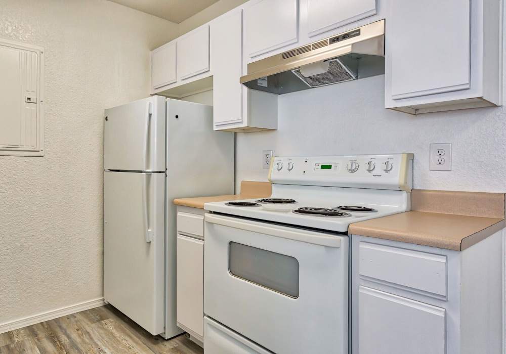 Kitchen with range and refrigerator at The Gardens At Duncan Apartments in Duncan, Oklahoma