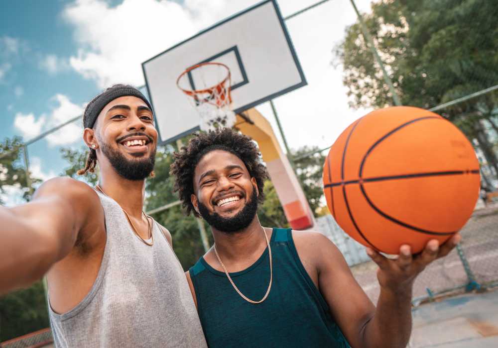 Group of people playing basketball on an outdoor court near Unionville Station Townhomes in Hilton, New York