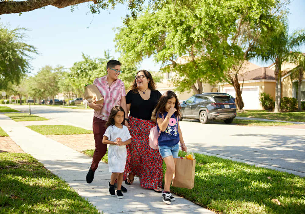People walking together along a residential sidewalk near Unionville Station Townhomes in Hilton, New York