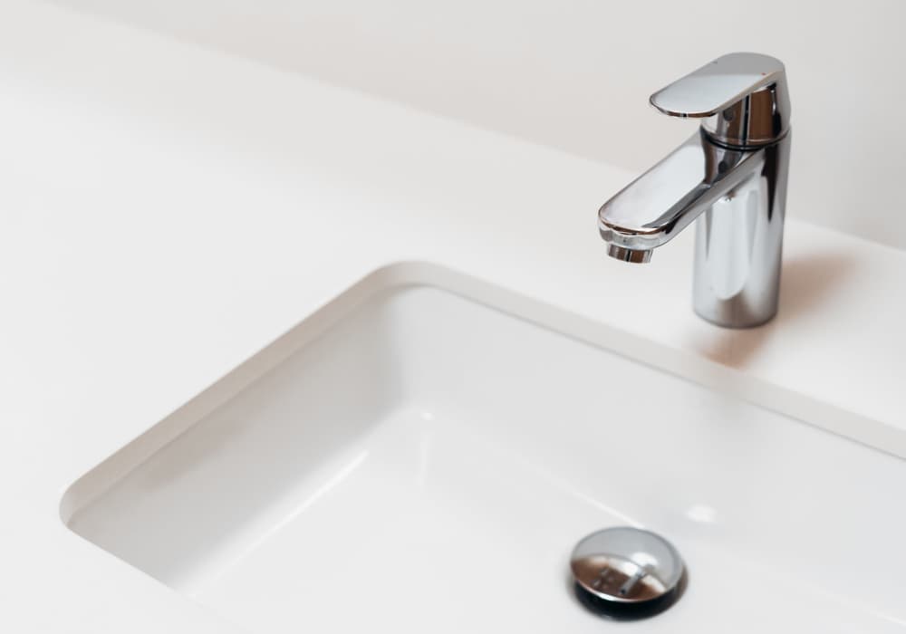 Modern chrome faucet over white sink at Jefferson Manor Townhomes in Fairport, New York