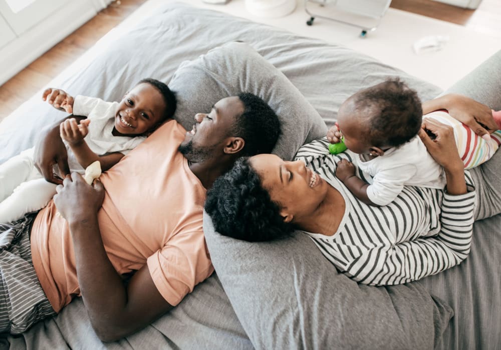 Family playing together on the bed at Parkway East Apartments in Caldwell, New Jersey