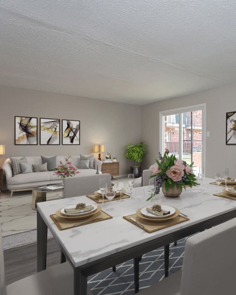 A dining room set with the living room in the background at Cambridge Place Apartments in Montgomery, Alabama