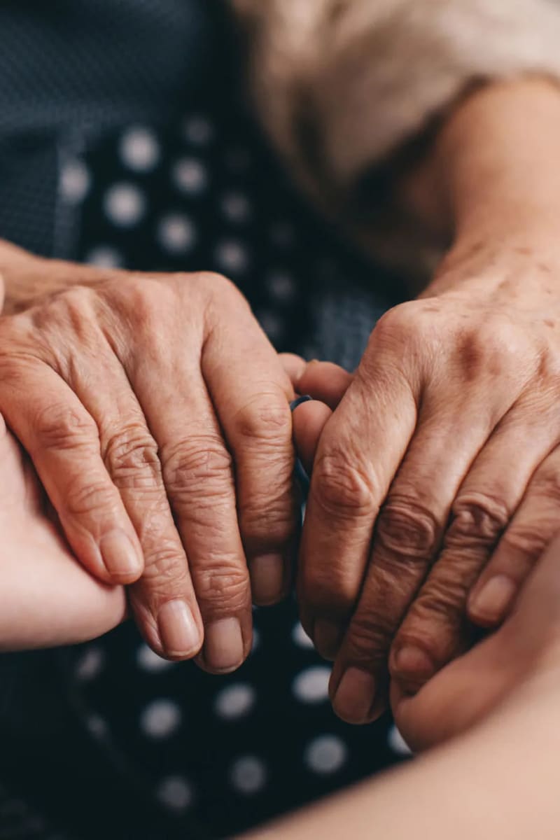 resident holding hands with a younger family member at Carriage Inn Katy in Katy, Texas