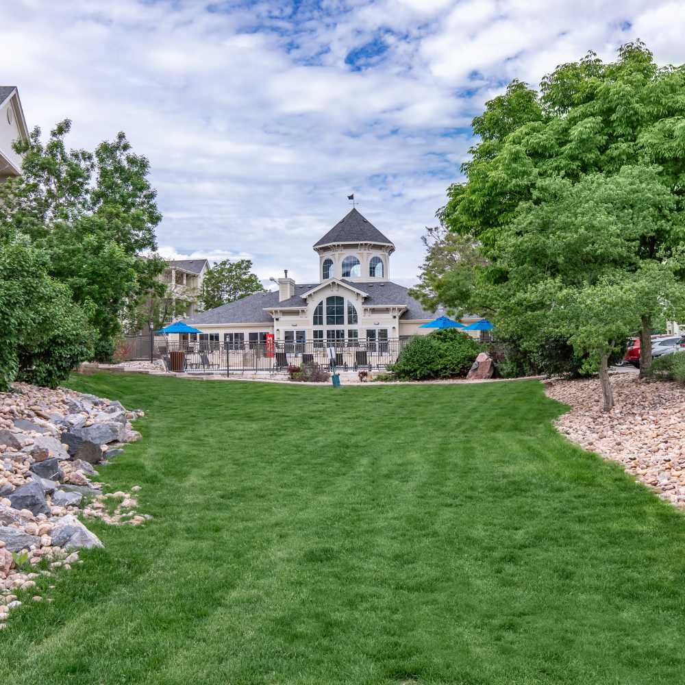 Community view with green lawn and trees at One Belmar Place in Lakewood, Colorado