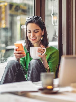 A woman checks her work email from a cafe near The Hardison in Salt Lake City, Utah