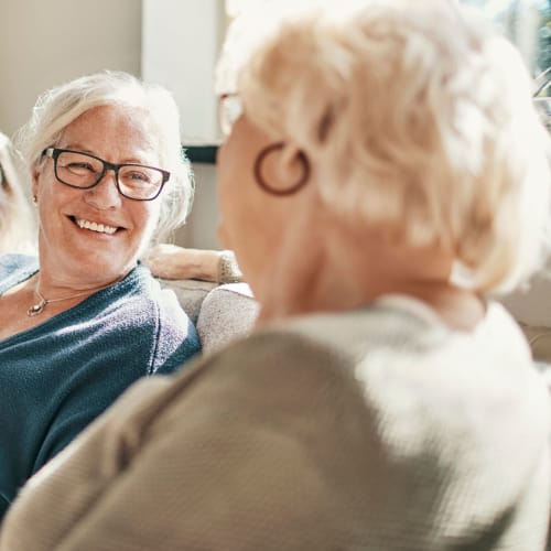 two residents talking on a couch at Oxford Springs Tulsa Memory Care in Tulsa, Oklahoma