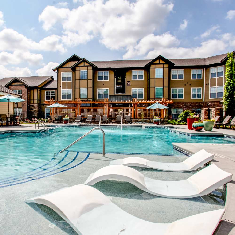 Charming poolside oasis featuring a sparkling water pool surrounded by lush landscaping and inviting seating areas at Avonlea Square in Smyrna, Georgia