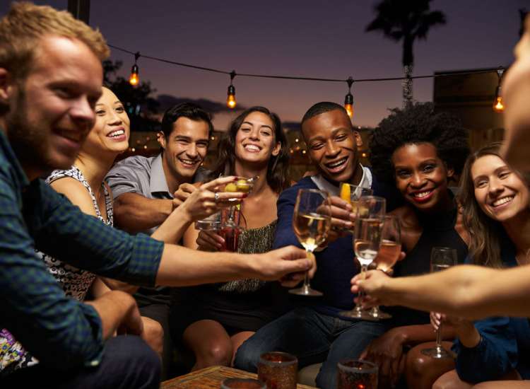 A cheerful gathering of friends toasting with wine glasses at Broadway Street Apartments in Lowell, Massachusetts
