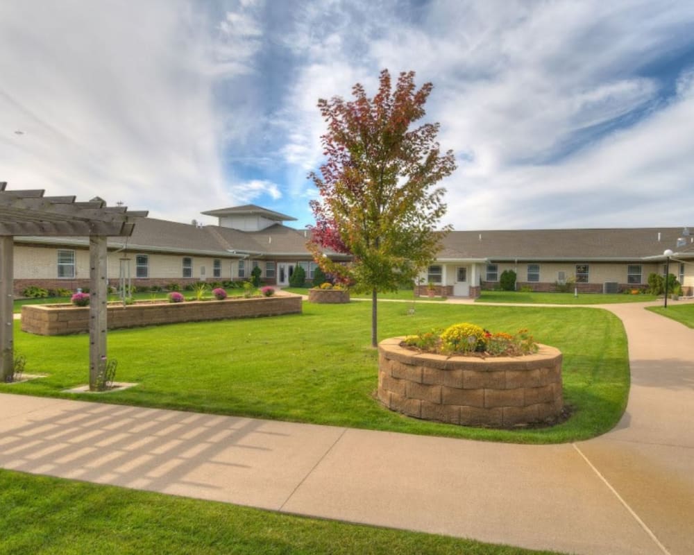 Courtyard with green lawns and paved walkways at Addington Place of Muscatine in Muscatine, Iowa