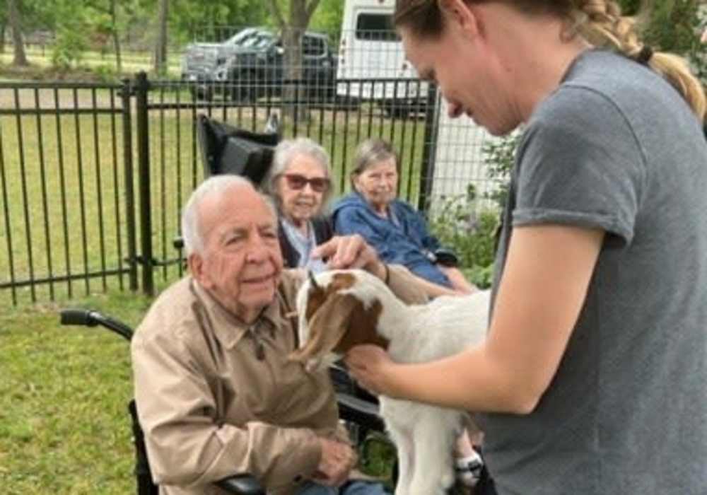 Resident petting a goat at Truewood by Merrill, Keller in Keller, Texas
