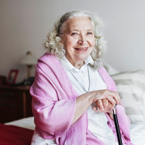 resident with a cane smiling at the camera at Oxford Springs Tulsa Memory Care in Tulsa, Oklahoma