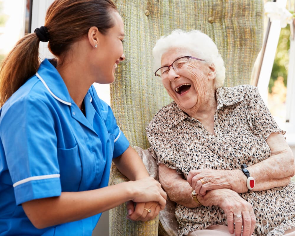 Caregiver and resident laughing outside together at The Pillars of Mankato in Mankato, Minnesota