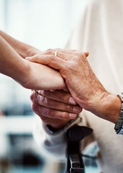 Staff member holding a resident's hands at Grand Villa of DeLand in DeLand, Florida