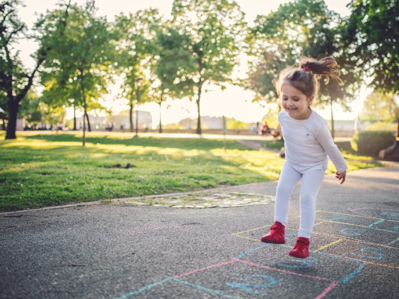 Child playing hopscotch at The August Apartments in Lexington, Kentucky