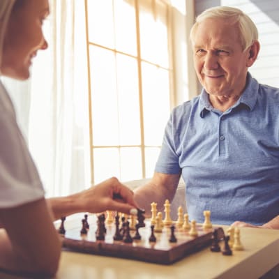 Resident playing chess with his daughter at Westminster Memory Care in Aiken, South Carolina