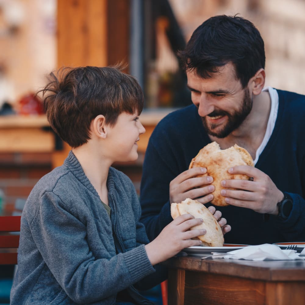 Father and son enjoying a meal near Capri Creek Apartments in Petaluma, California