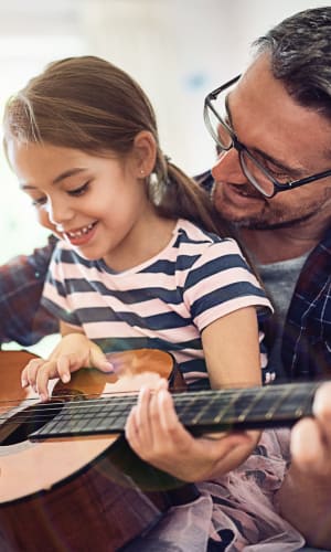 Resident and his daughter playing guitar in their home at The Majestic at Hewitt in Hewitt, Texas