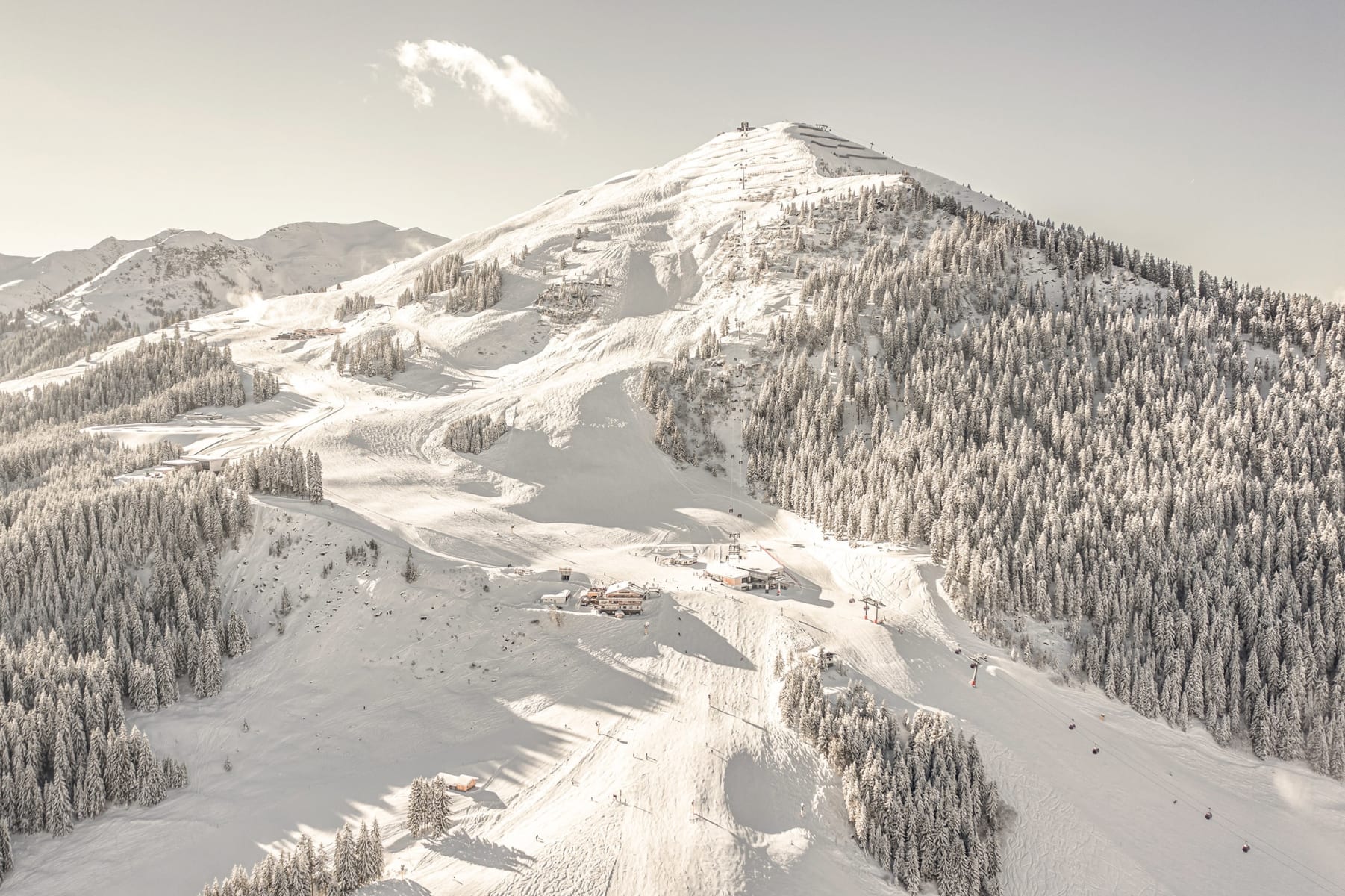 Eine schneebedeckte Landschaft im Glemmtal mit dem Glemmtalerhof und zahlreichen Skipisten.