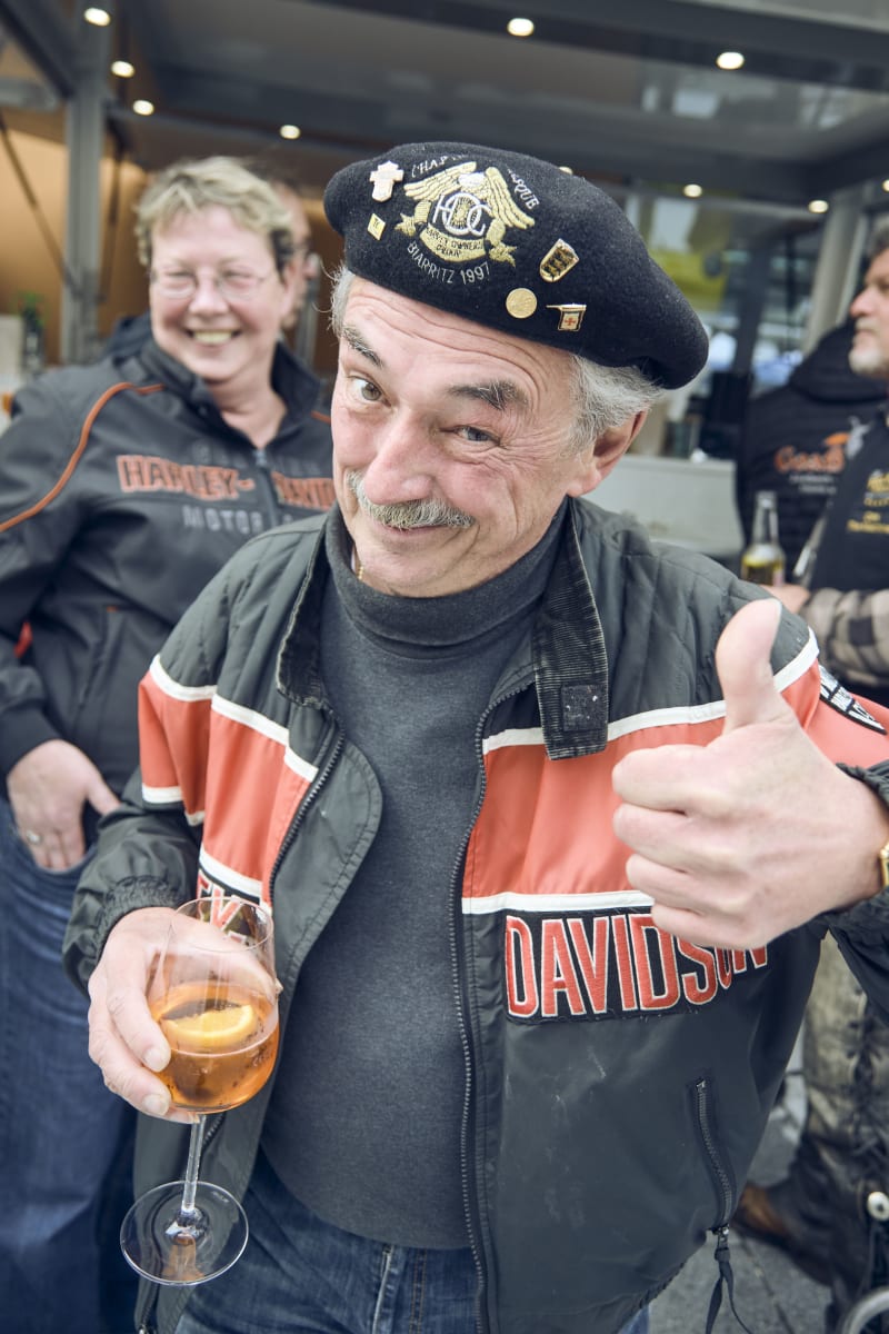 Ein Mann mit einem Drink und Daumen hoch, freudige Stimmung. Glemmtalerhof in Hinterglemm könnte sichtbar sein.