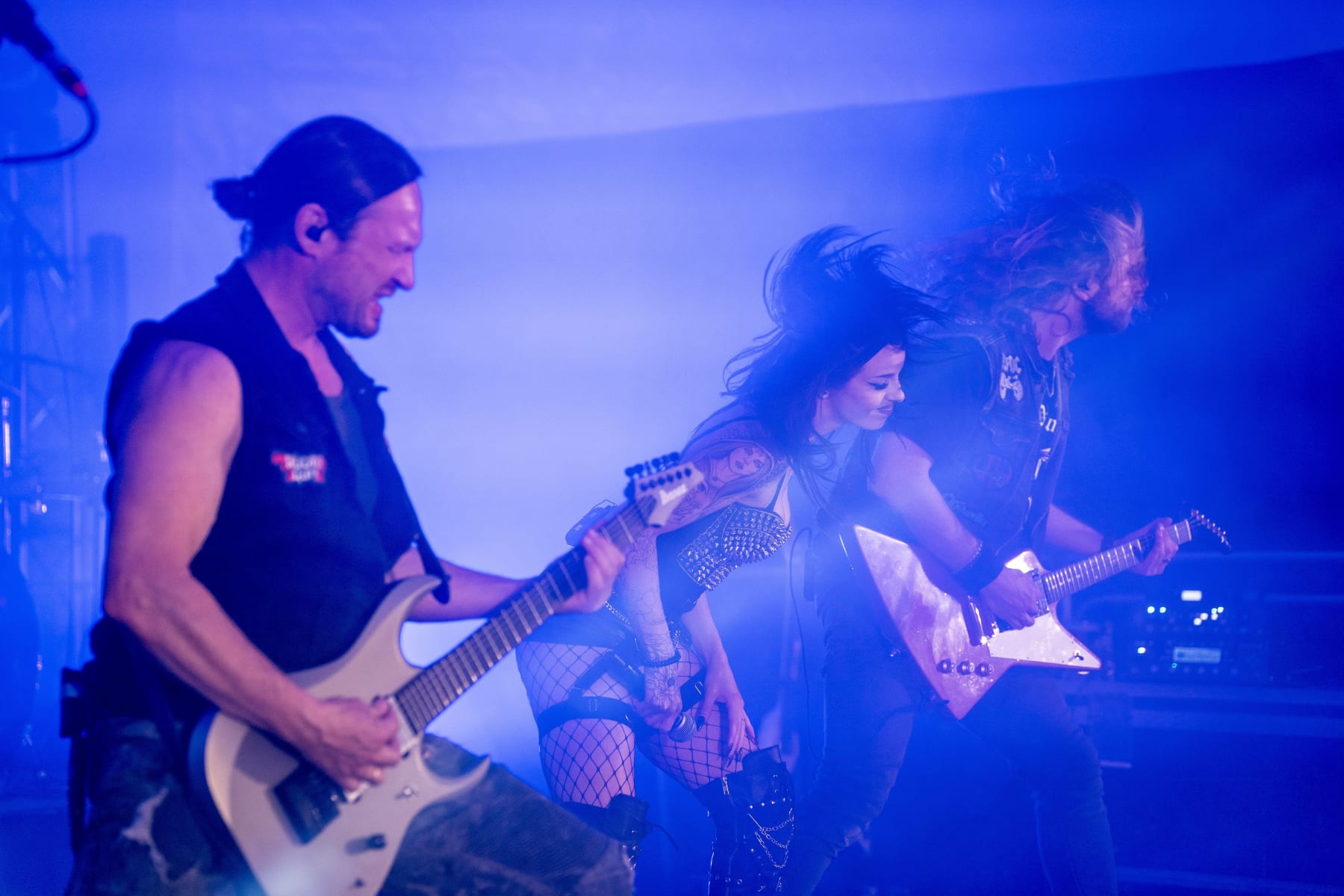 Rockband Audiogun performt live begeistert auf einer Bühne im Festzelt, im Hintergrund leuchtet der Glemmtalerhof in Hinterglemm.