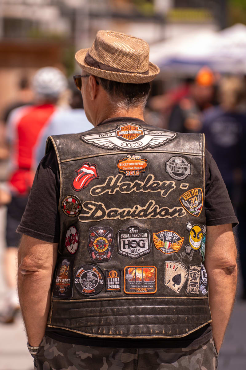 Ein Mann mit einem stylischen Harley-Davidson-Westen und Hüte, Besuch des Glemmtalerhofs in Hinterglemm.