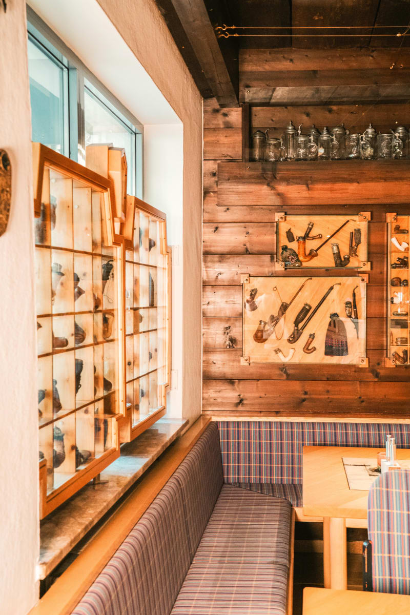 A cozy restaurant area in Glemmtalerhof with wooden walls and traditional collections.