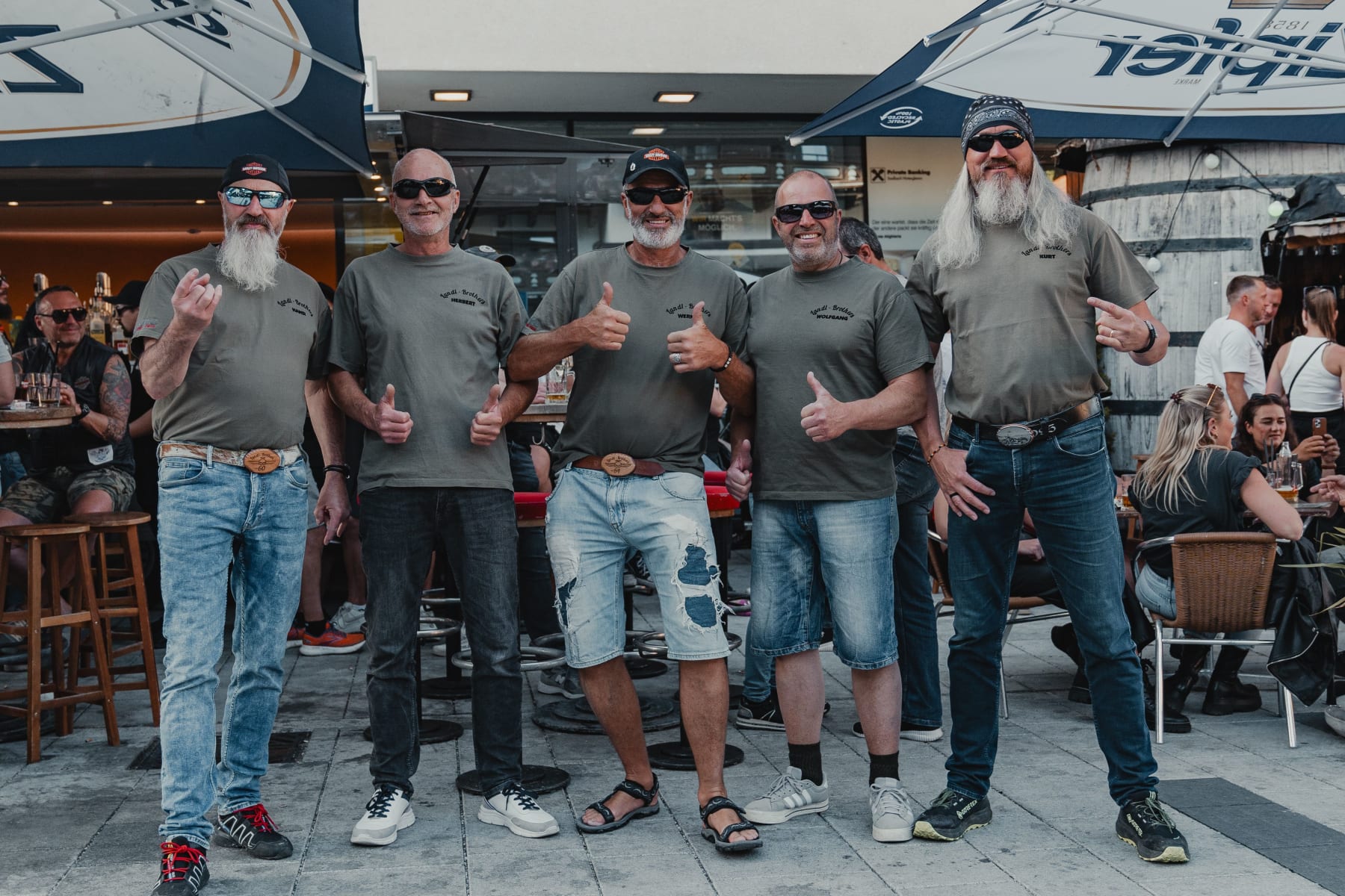 Fünf Männer mit Sonnenbrillen und T-Shirts stehen im Glemmtal und zeigen Daumen hoch.