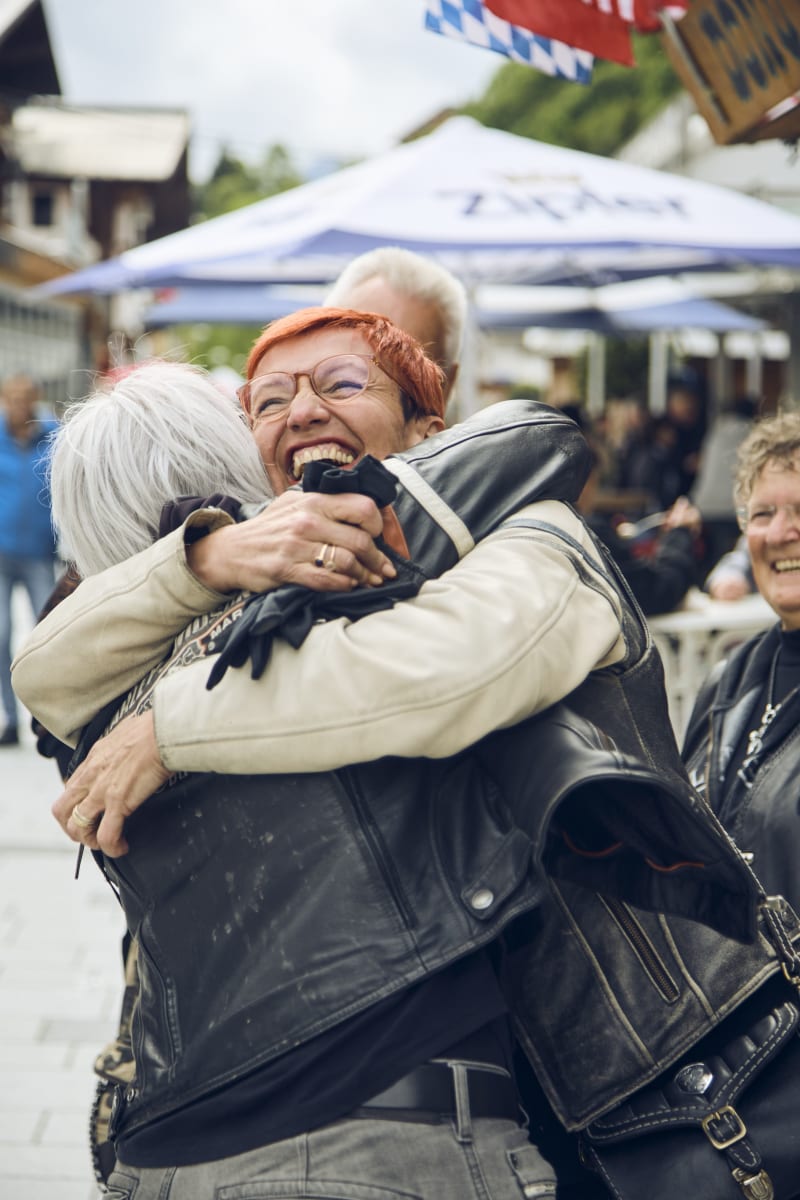 Freunde umarmen sich glücklich im Glemmtal. Freude und Gemeinschaft sind hier spürbar.