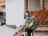 Eine Familie geht in Hinterglemm spazieren, umgeben von Holzelementen und Bergen im Glemmtal.