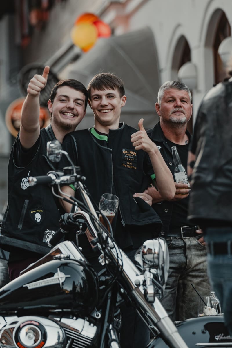 Junge Männer mit Motorrädern und Getränken, viel Spaß im Glemmtal beim Glemmtalerhof.