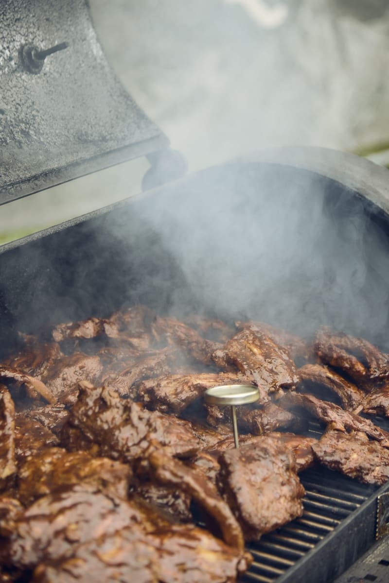 Im Glemmtal brutzelt saftiges Fleisch auf dem Grill, umhüllt von dichten Rauchschwaden.