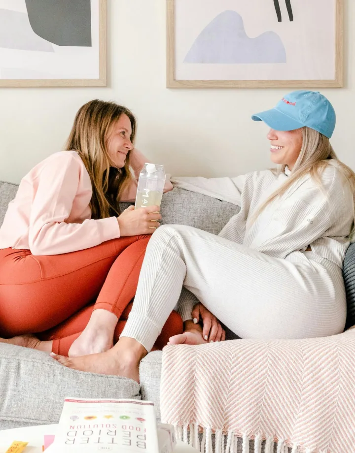 Imagem de duas pessoas sentadas no sofá conversando