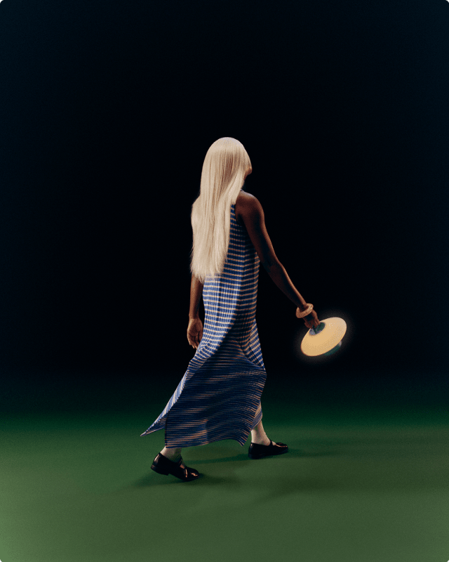 Person carrying a Pier Single lamp across a darkened room.