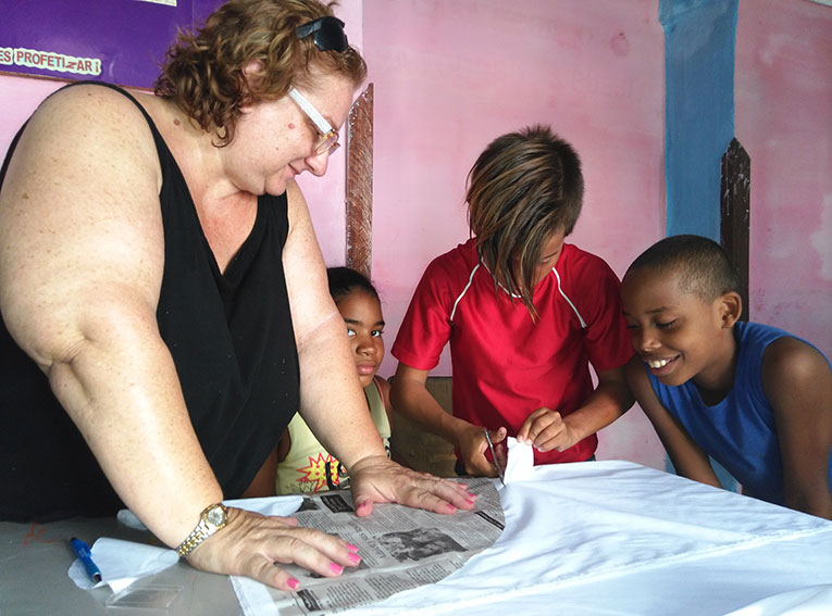 Volunteer in Cuba teaching students how to sew