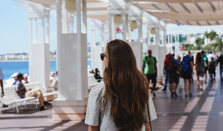 girl with long hair walking along boardwalk in France