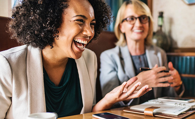 Woman laughing at a meeting/coffee date with friends