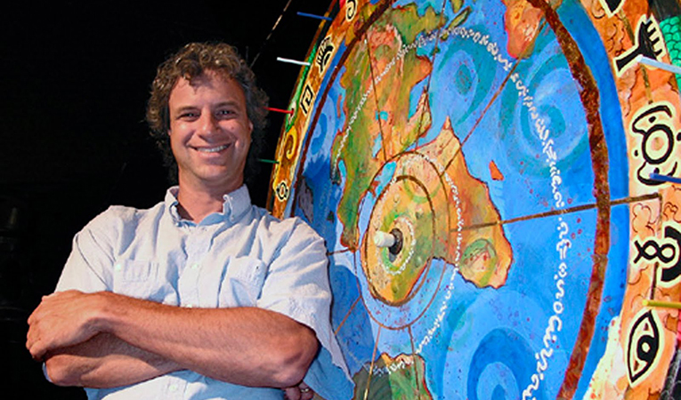 Jeff Greenwald with a big wheel of the world