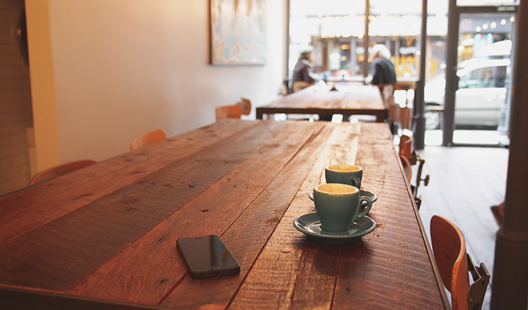 Cafe in montreal with two lattes on reclaimed wood table