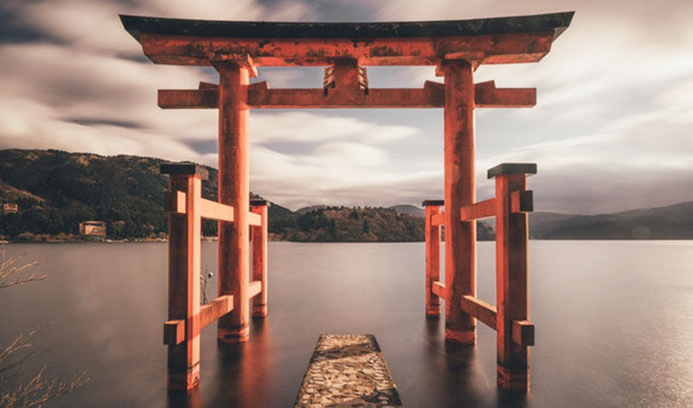 A orange torii gate in a lake