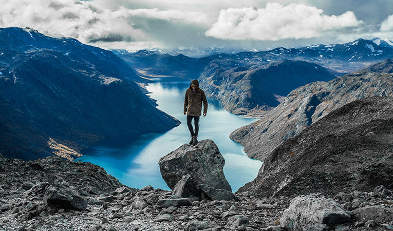 Man standing on mountain cliff in Norway
