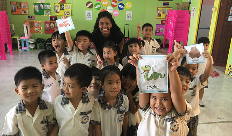 Girl poses with her ESL students in Asia