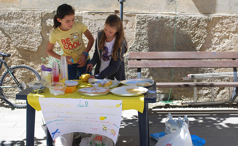 Two girls standing at a lemonade stand