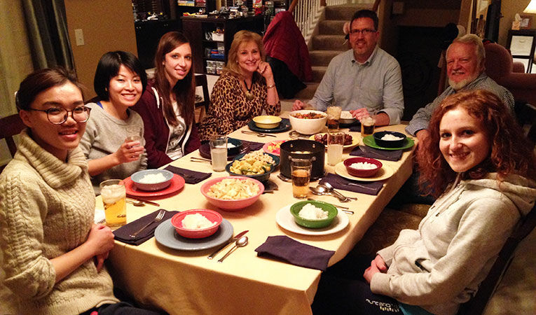 Volunteers having dinner with their host family