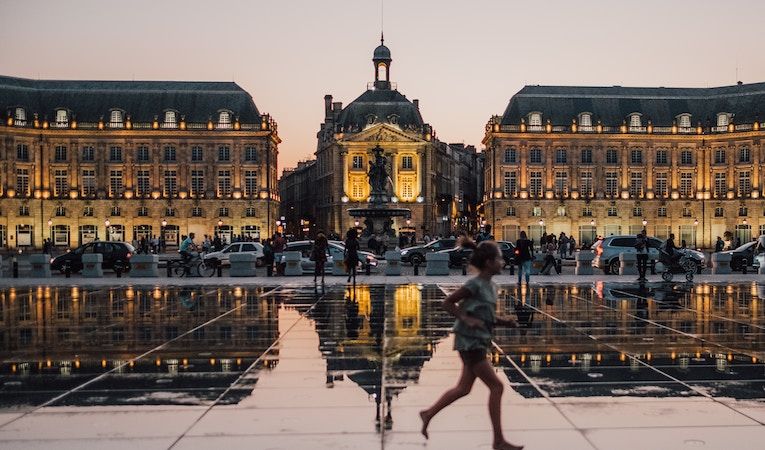 Night in Bordeaux, girl running across plaza 