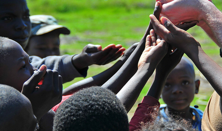 Children in Haiti holding out their hands