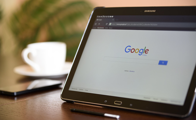 Google open on a Samsung tablet on a table with coffee