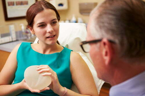 Woman holding breast implant