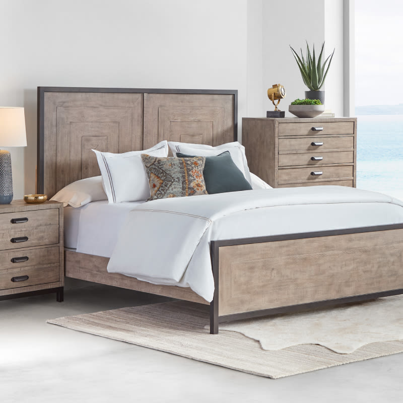 A gray wooden queen size bedroom furniture set including a bed, chest of drawers, and a nightstand.