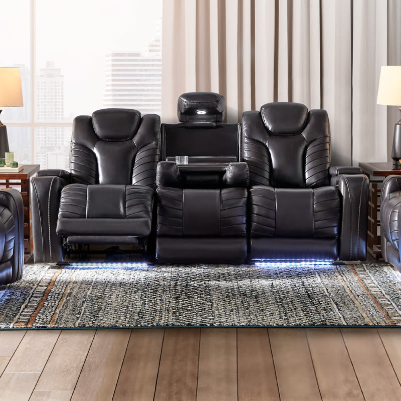 A power reclining sofa in black leather with lighting features underneath.